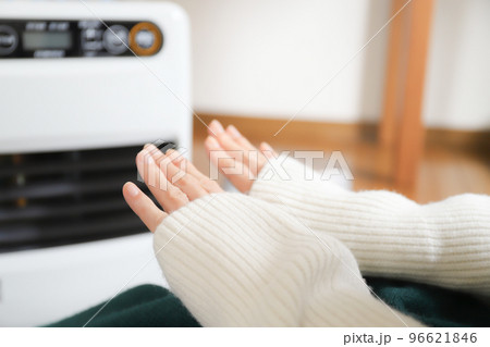 ファンヒーターで暖まる女性 96621846
