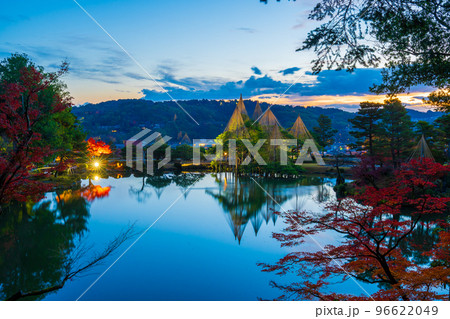 冬の風物詩雪吊りと紅葉が兼六園の霞ヶ池に美しく反射する早朝の風景｜石川県金沢市 96622049