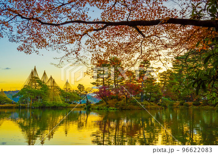 冬の風物詩雪吊りと紅葉が兼六園の霞ヶ池に美しく反射する早朝の風景｜石川県金沢市 96622083