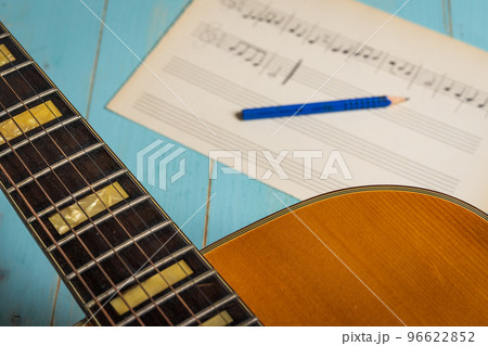 Music recording scene with guitar, music sheet and pencil on wooden table 96622852