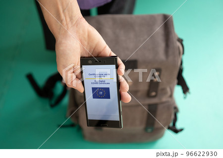 Woman showing on smartphone Italian EU Digital Covid Certificate.  96622930