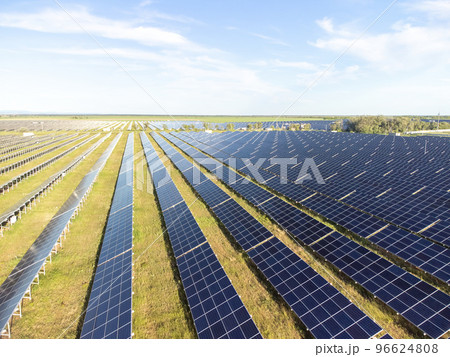 Aerial top view of a solar panels power plant. Photovoltaic solar panels at sunrise and sunset in countryside from above. Modern technology, climate care, earth saving, renewable energy concept. 96624808