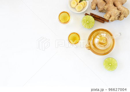 Top view of a cup of tea with ginger root, lime, cinnamon and teapot on white background. Health drink concept.. Top view of a cup of tea with ginger root, lime, cinnamon and teapot on white background. Health drink concept.. 96627004
