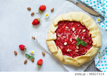 Fresh homemade strawberries galette with nut cream on a gray stone or slate background. Top view flat lay background. Copy space. Fresh homemade strawberries galette with nut cream on a gray stone or slate background. Top view flat lay background. Copy space. 96627314