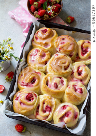 Fresh Homemade Rolls Buns with strawberry with Cream Cheese in glaze for Breakfast on a stone or slate gray background. Fresh Homemade Rolls Buns with strawberry with Cream Cheese in glaze for Breakfast on a stone or slate gray background. 96627397