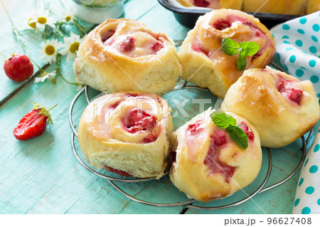 Fresh Homemade Rolls Buns with strawberry with Cream Cheese in glaze for Breakfast on kitchen table. Copy space. Fresh Homemade Rolls Buns with strawberry with Cream Cheese in glaze for Breakfast on kitchen table. Copy space. 96627408