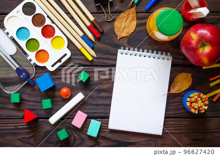 Back to school background with school supplies, autumn leaves and apple on a wooden table. Top view flat lay background, copy space. Back to school background with school supplies, autumn leaves and apple on a wooden table. Top view flat lay background, copy space. 96627420