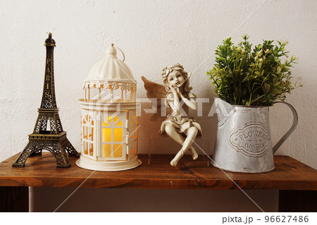 Eiffel tower, white lantern, ceramic doll and artificial plant on wooden shelf Interior home decoration Eiffel tower, white lantern, ceramic doll and artificial plant on wooden shelf Interior home decoration 96627486