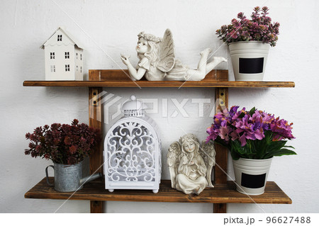 white lantern with ceramic dolls and artificial plant Interior home decoration on wooden shelf 96627488