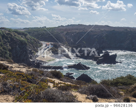 View of the small anchorage bay with fishing port at Azenha do Mar from the surrounding cliffs Odemira, Portugal. Sunny day, Clear blue sky. 96628136