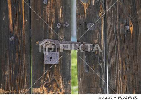 old wooden gate with rusty padlock. Background 96629820