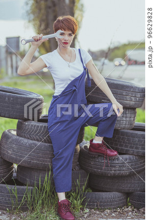 attractive woman mechanic in overalls holding wrench attractive woman mechanic in overalls holding wrench 96629828