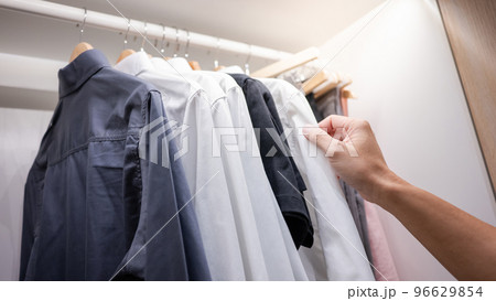 Male hand choosing shirt in closet 96629854