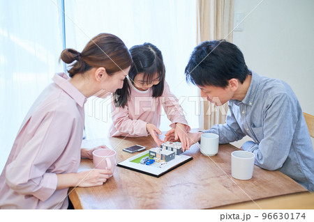 戸建の模型を見ながら話し合う家族 96630174