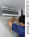 エアコンを洗浄するハウスクリーニングの作業員 96630874