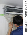 エアコンを洗浄するハウスクリーニングの作業員 96630875