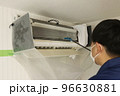 エアコンを洗浄するハウスクリーニングの作業員 96630881