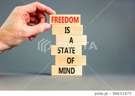 Freedom in mind symbol. Concept words Freedom is a state of mind on wooden blocks on a beautiful grey table grey background. Businessman hand. Business freedom is a state of mind concept. 96632975