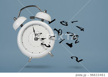 Time is running out. White alarm clock with flying numbers as a symbol of lost time. The concept of time is running out, loss or lack of time, an alarm clock with numbers shatters into small pieces. 96633461