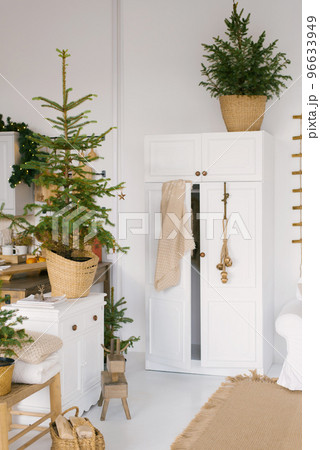 Wardrobe in the decorated bedroom for Christmas and New Year. Christmas trees with lights are in the room in the house 96633949