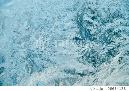 Frosty patterns on glass. Christmas background. Blue ice on winter window. 96634128