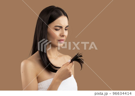 Unhappy woman holding her hair split ends in hand 96634414
