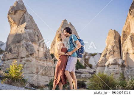 Happy couple tourists on background of Unique geological formations in Love Valley in Cappadocia, popular travel destination in Turkey Happy couple tourists on background of Unique geological formations in Love Valley in Cappadocia, popular travel destination in Turkey 96634818