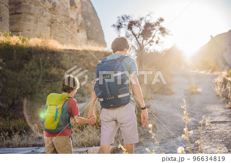 Father and son tourists on background of Unique geological formations in Love Valley in Cappadocia, popular travel destination in Turkey. Traveling with children in Turkey concept Father and son tourists on background of Unique geological formations in Love Valley in Cappadocia, popular travel destination in Turkey. Traveling with children in Turkey concept 96634819