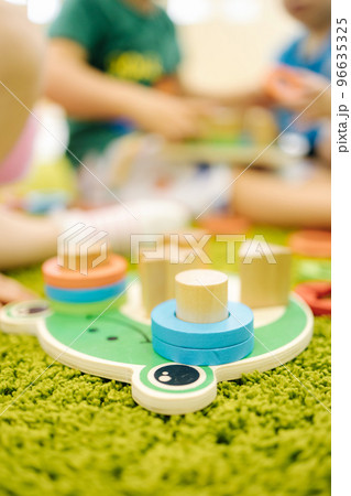 Little children play with wooden toys in kindergarden Little children play with wooden toys in kindergarden 96635325