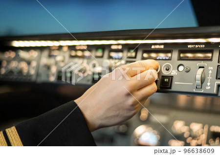 Close-up of a pilot's hand on an airplane control panel. Close-up of a pilot's hand on an airplane control panel. 96638609