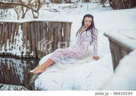 Attractive woman lying near the font in a white dress 96639294