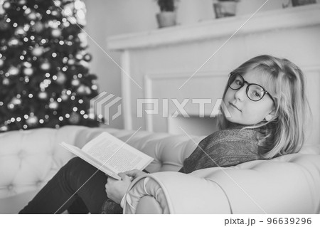 Beautiful girl reading a book on the sofa near the christmas tree 96639296