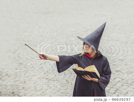 young sorceress in the castle conjuring by magic wand 96639297