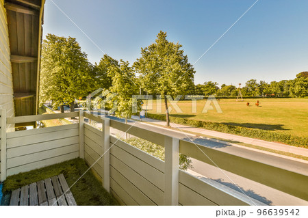 Panorama view of meadow with an empty sidewalk street with cars, trees and lanterns 96639542
