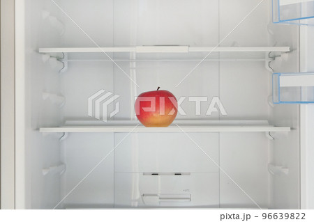 Red ripe apple on the shelf in the fridge. Health starvation, lose weight. Raw diet, starving concept. Red ripe apple on the shelf in the fridge. Health starvation, lose weight. Raw diet, starving concept. 96639822