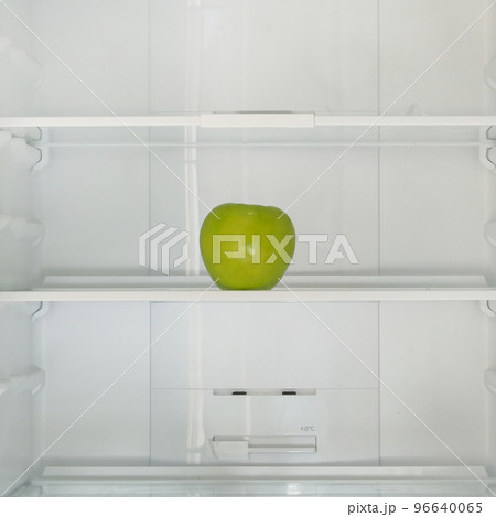 Green ripe apple on the shelf in the fridge. Health starvation, lose weight. Raw diet, starving concept. 96640065