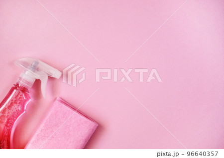 Detergents in spray. Cleaning accessories. Top view of pink cleaning supplies on pink background. Close up. 96640357