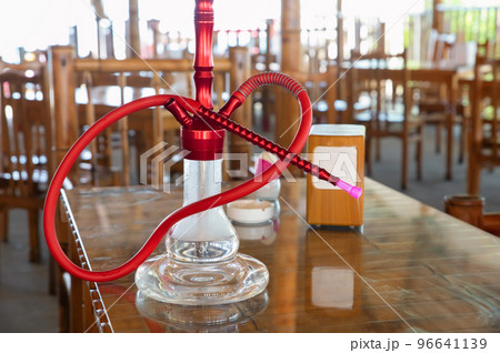 Shisha hookah with red hot coals stands on a table 96641139