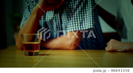 家でうなだれるミドル男性と彼を慰めるミドル女性	 96643356