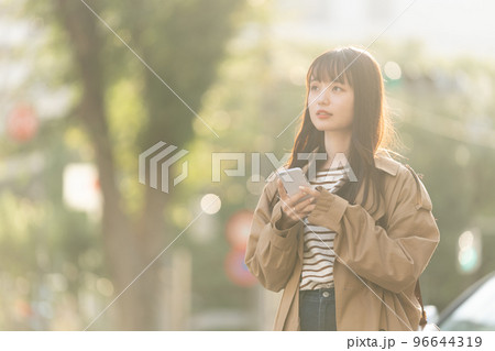 屋外でスマホを操作する若い女性 96644319