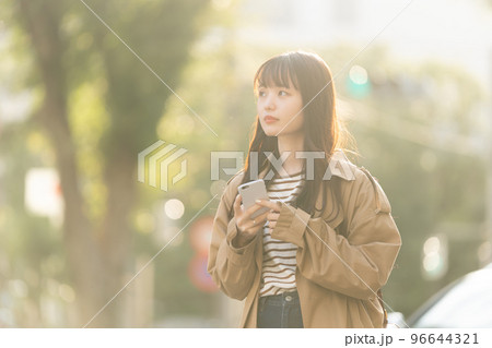 屋外でスマホを操作する若い女性 屋外でスマホを操作する若い女性 96644321