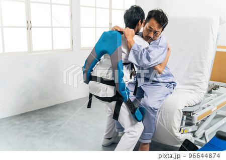 パワーアシストスーツをつけて患者を抱える看護師　移乗介助機器 96644874