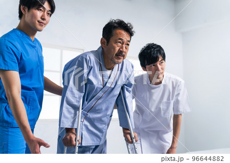 松葉杖を使ってリハビリする患者とケアスタッフ 96644882