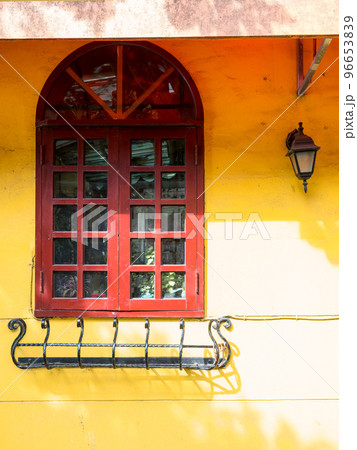 Brown wooden window on the yellow facade 96653839