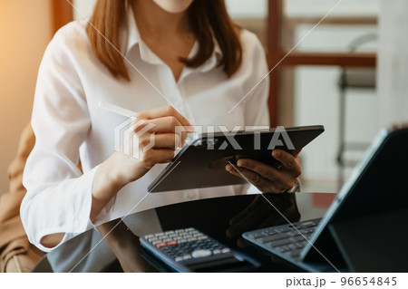 businesswoman hand using smart phone, tablet payments and holding credit card online shopping, omni channel, digital tablet docking keyboard computer at office 96654845