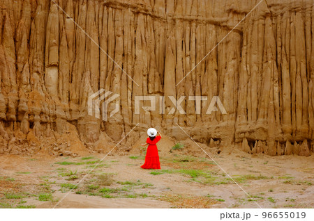 Women and landscape of soil textures eroded sandstone pillars, columns and cliffs, natural erosion of water and wind, Sao Din Na Noi, Hom Chom, Khok Suea at sri nan national park in Nan Province. 96655019