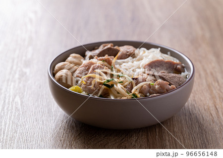 Rice noodles soup with pork in bowl on wooden background, Asian food 96656148