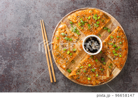 Kimchijeon Traditional Pancake From South Korea made from kimchi and green onion closeup on the wooden board. Horizontal top view Kimchijeon Traditional Pancake From South Korea made from kimchi and green onion closeup on the wooden board. Horizontal top view 96658147