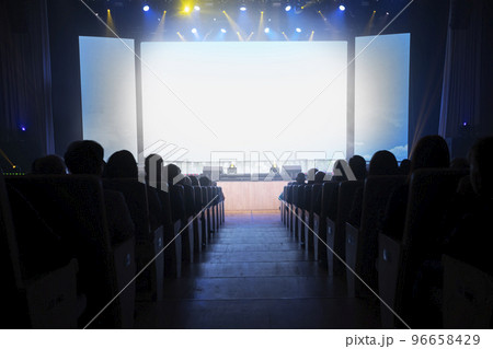 People in the cinema in front of an empty white screen. People in the cinema in front of an empty white screen. 96658429