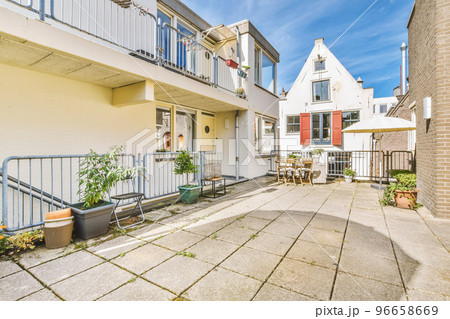 Panorama view of brick houses from an empty sidewalk street with cars, trees and lanterns 96658669